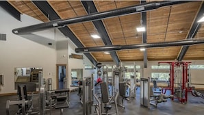 A gym with various exercise machines, a wooden ceiling, and large windows. - Valley Vista Escape (Durango)
