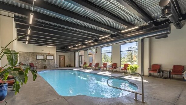 An indoor swimming pool with a clear view of the surrounding area, including chairs and a view of the outdoors. - Valley Vista Escape (Durango)