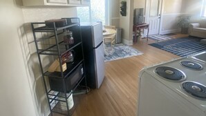 A kitchen with a refrigerator, stove, and a dining area with a chair and table. - Cozy 1-bedroom apartment in lovely Alma with WiFi, AC (Alma)