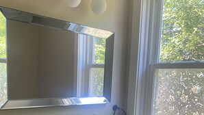 A bathroom with a glass sink, a mirror, a towel rack, and a window with frosted glass. - Cozy 1-bedroom apartment in lovely Alma with WiFi, AC (Alma)