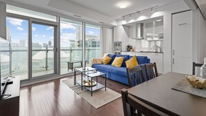 A modern apartment with a living room, dining area, and kitchen. - Lovely Downtown Condo with Iconic CN Tower View! (Toronto)