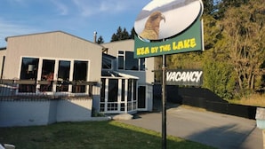 Une pancarte indiquant le nom d’une propriété, « Sea by the Lake », avec une vue sur une montagne et un lac.
