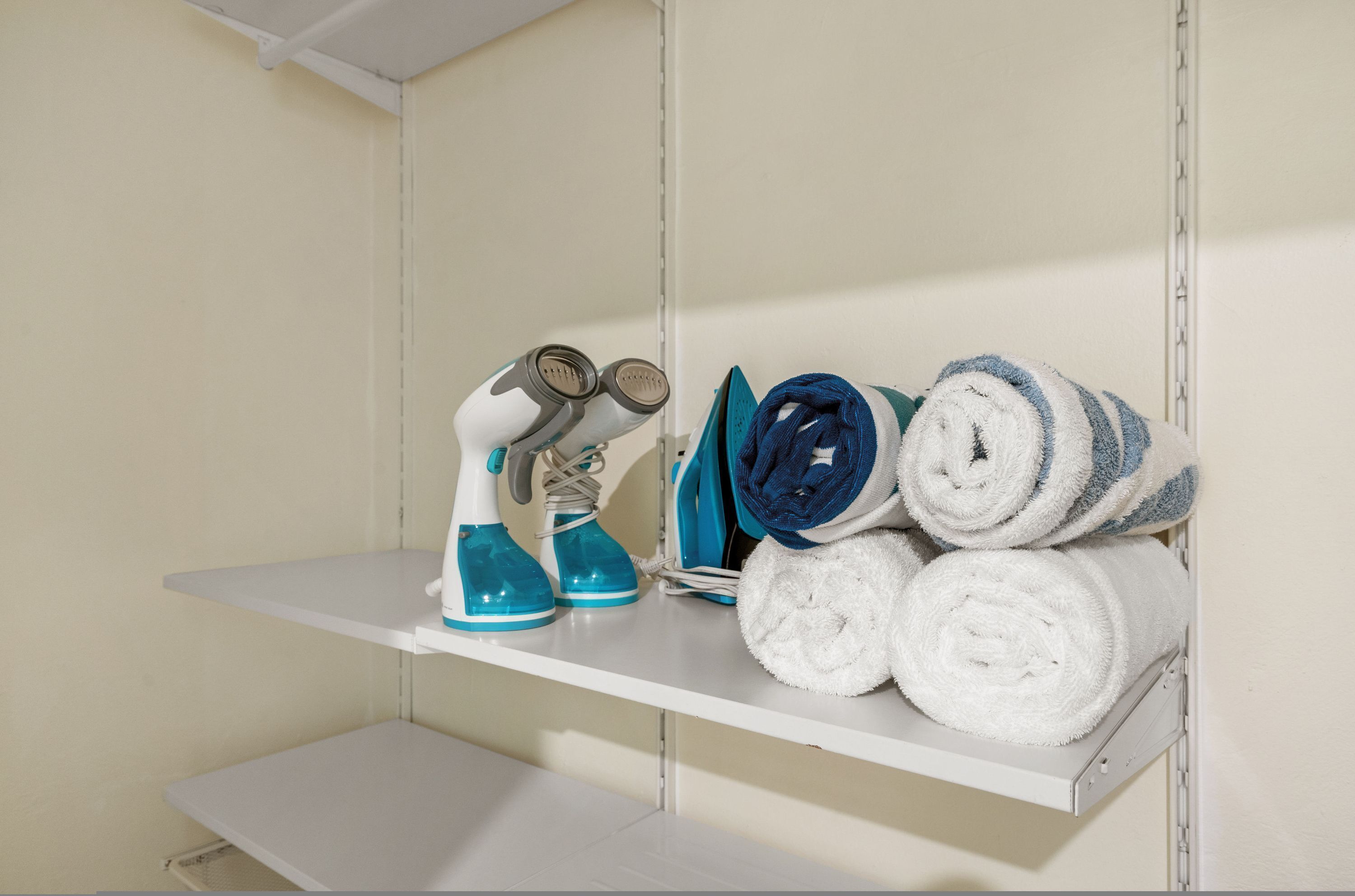 A shelf with cleaning supplies and towels.