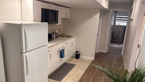 A modern kitchen with white cabinetry, a built-in microwave, and a stainless steel sink.