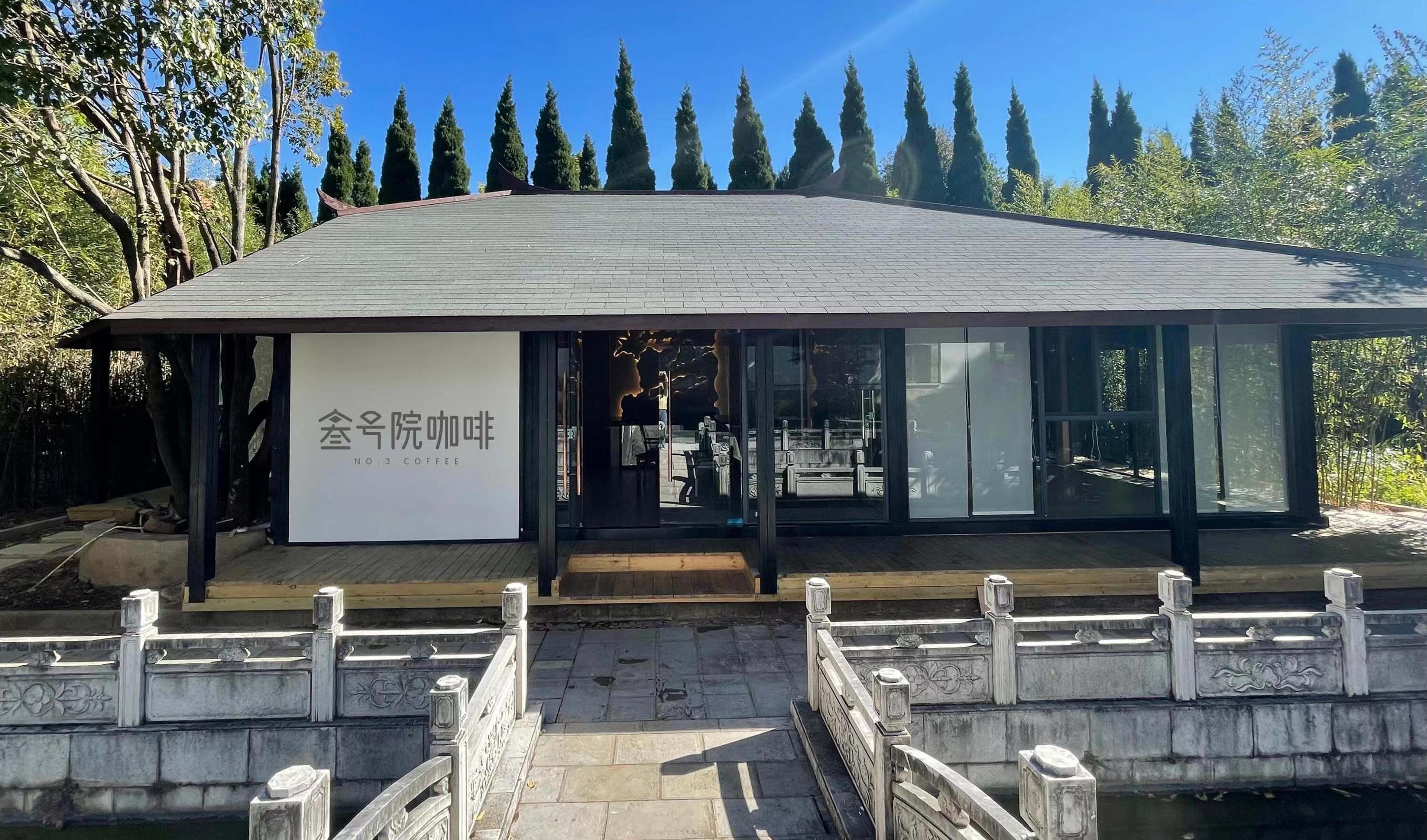 A modern building with a sign reading "No.3 Coffee" and a view of the interior through large windows.