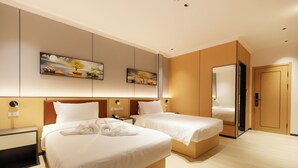 Una habitación de hotel con dos camas, un espejo grande y obras de arte en la pared.