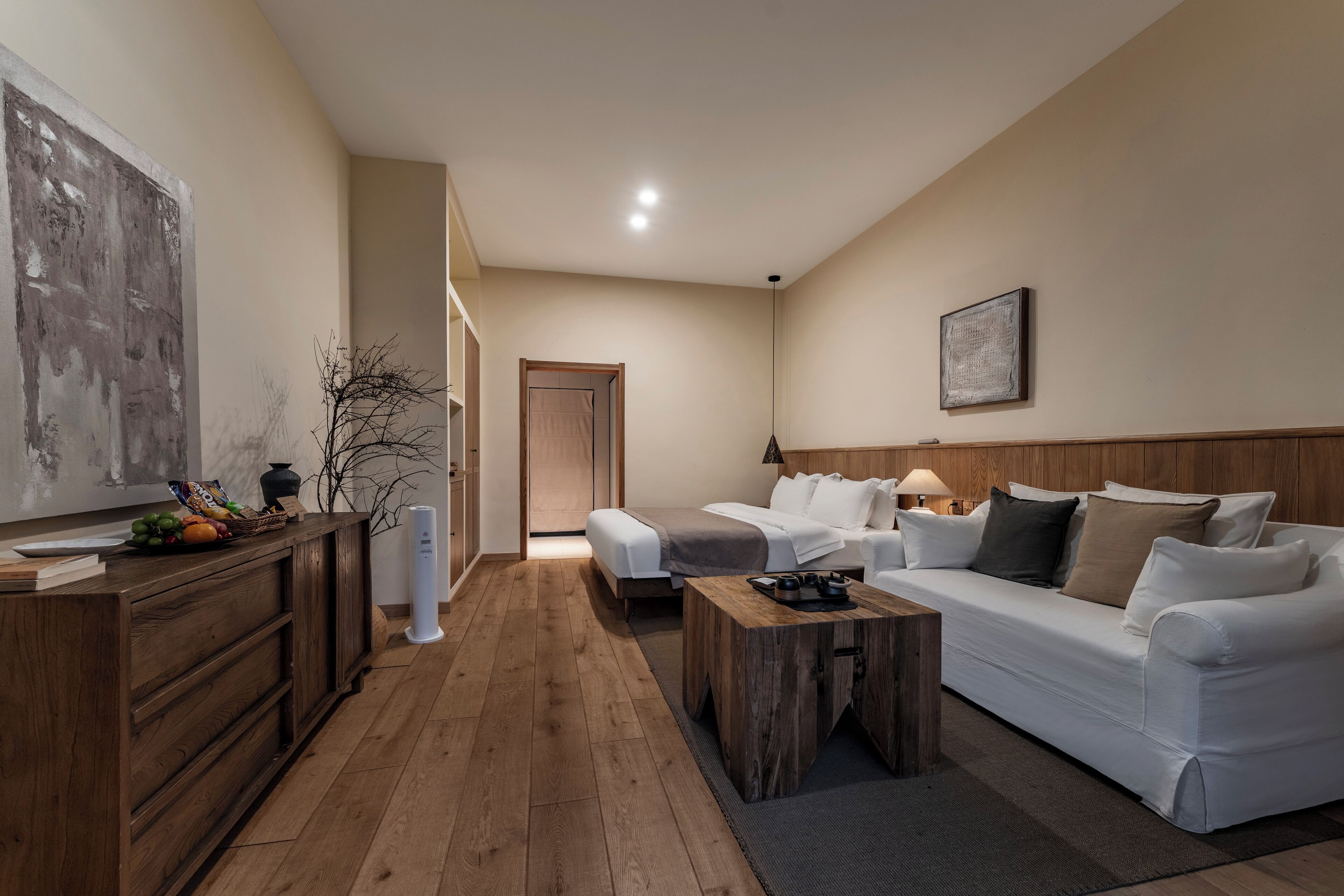 Uma sala de estar moderna com um sofá, uma mesa de centro e um armário de madeira.