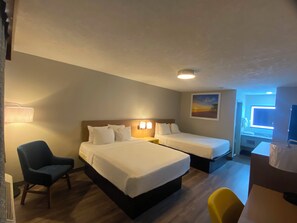 A hotel room with two beds, a desk, a chair, and a painting on the wall. - Days Inn & Suites by Wyndham Albuquerque West (Albuquerque)