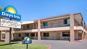 A Days Inn building with a sign indicating newly renovated rooms, indoor pool, spa, breakfast, and cable TV.