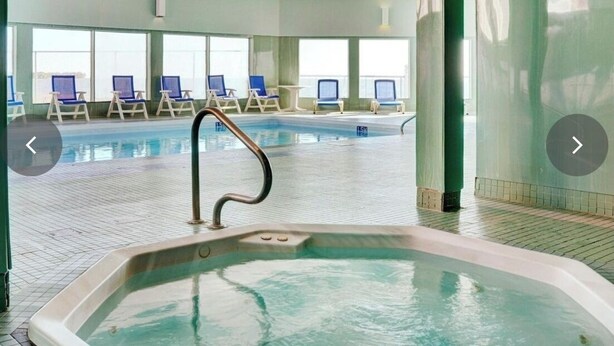 A swimming pool area with lounge chairs and a hot tub. - One Bedroom for Icelandic Festival week (Gimli)