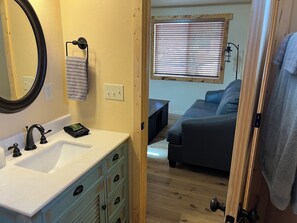 A bathroom with a sink, mirror, and towel rack. - Mountain Peaks Inn, SILVER PEAK SUITE, Downtown Hill City (Hill City)