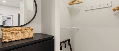 A modern bathroom with a black vanity, a round mirror, and a wicker basket.