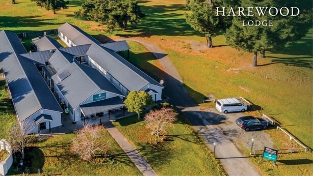 An aerial view of a lodge with multiple buildings, surrounded by trees and a golf course. - Harewood Lodge  (Christchurch)