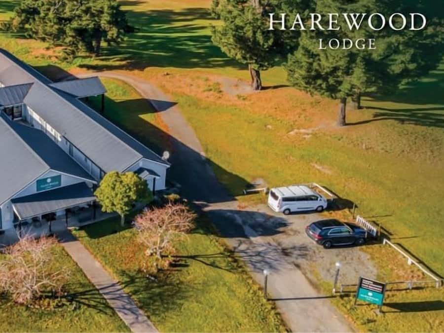 An aerial view of a lodge with multiple buildings, surrounded by trees and a golf course.