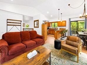 A spacious living area with a red sofa, a wooden coffee table, and a patterned rug.