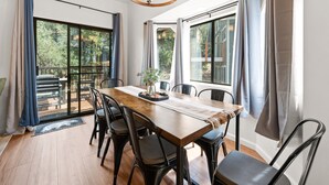 A dining area with a wooden table, black chairs, and a chandelier.