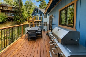 Una terraza con una parrilla y mobiliario exterior.