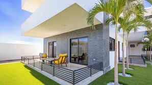 A modern house with a balcony, outdoor seating, and palm trees. - Quiet and elegant place in Cabo (Cabo San Lucas)