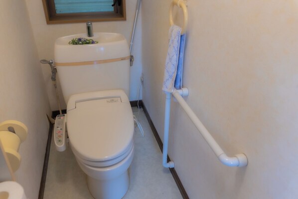 Un baño pequeño con inodoro, lavamanos y ducha.