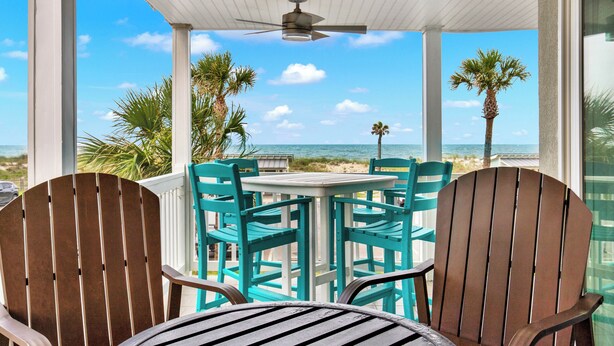 A covered outdoor seating area with a table and chairs, overlooking the beach and ocean. - Your Tybee Island Getaway! | Heated Pool Access (Tybee Island)