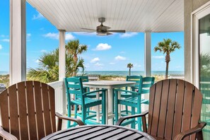 A covered outdoor seating area with a table and chairs, overlooking the beach and ocean. - Your Tybee Island Getaway! | Heated Pool Access (Tybee Island)