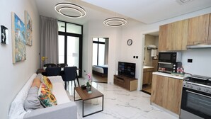 A modern apartment with a living room, dining area, and kitchen.