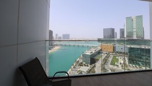 A high-rise building with a view of a coastal cityscape, including a bridge and modern architecture.
