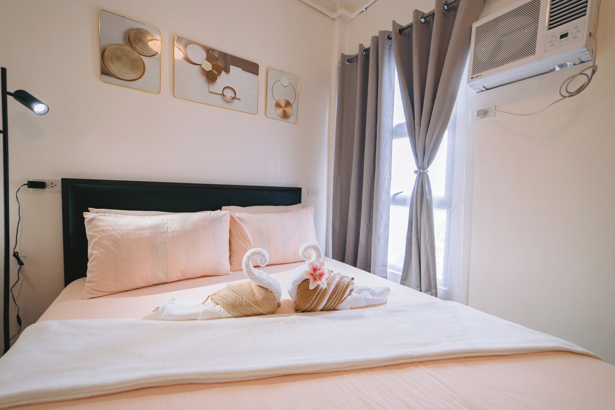 A neatly made bed with a headboard, pillows, and decorative swans on the bedspread.