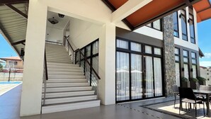 A modern building with a staircase, large windows, and a covered outdoor area. - APARTMENT IN LAPU-LAPU CITY RESORT TYPE-Near Mactan Airport 60 SQM.WITH 2BR (Lapu-Lapu)