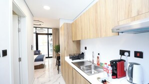 A modern kitchen with a sink, a coffee machine, and a kettle. - City-Linked Studio near Galleria and Cleveland (Abu Dhabi)