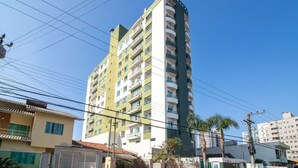 A multi-story residential building with balconies and a clear sky. - Apto 1 Quarto no centro em Itajaí CST0905 (Itajai)