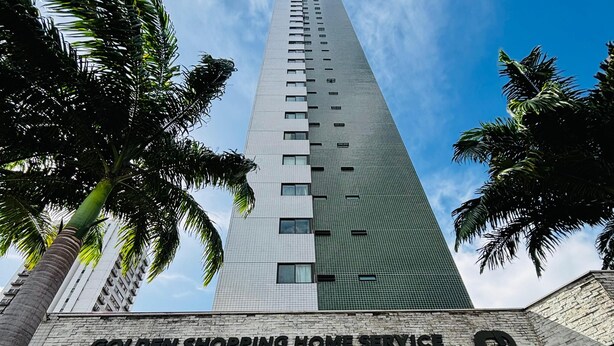 A tall building with a sign reading "GOLDEN SHOPPING HOME SERVICE" at the entrance. - Apartment 350 meters from the shopping mall (Boa Viagem Recife)