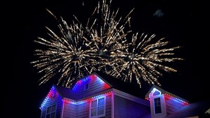 A house with a stone foundation and a gabled roof, illuminated by colorful LED lights. - Relaxing Arvada Escape Between Golden & Boulder (Arvada)