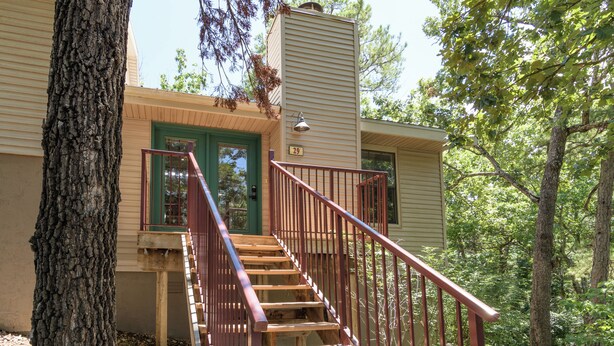 Un escalier en bois mène à une maison avec une porte verte et le numéro 29 sur le mur.
