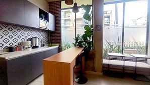 Una cocina moderna con una barra de café, una zona de comedor con vistas y un balcón con plantas.