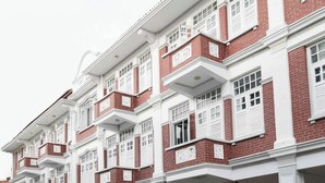 Een rij traditionele rode bakstenen gebouwen met witte accenten en meerdere balkons.
