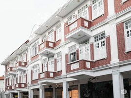 A row of traditional red brick buildings with white trim and multiple balconies.