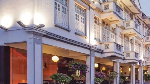 Een meerlaags hotel met een klassieke architectuur, voorzien van balkons en grote ramen.