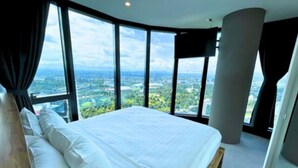 A bedroom with a large bed, a view of the city, and a modern design.