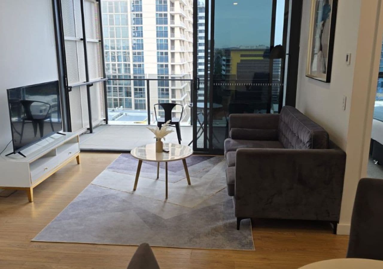 Een moderne woonkamer met een bank, een salontafel en een televisie.