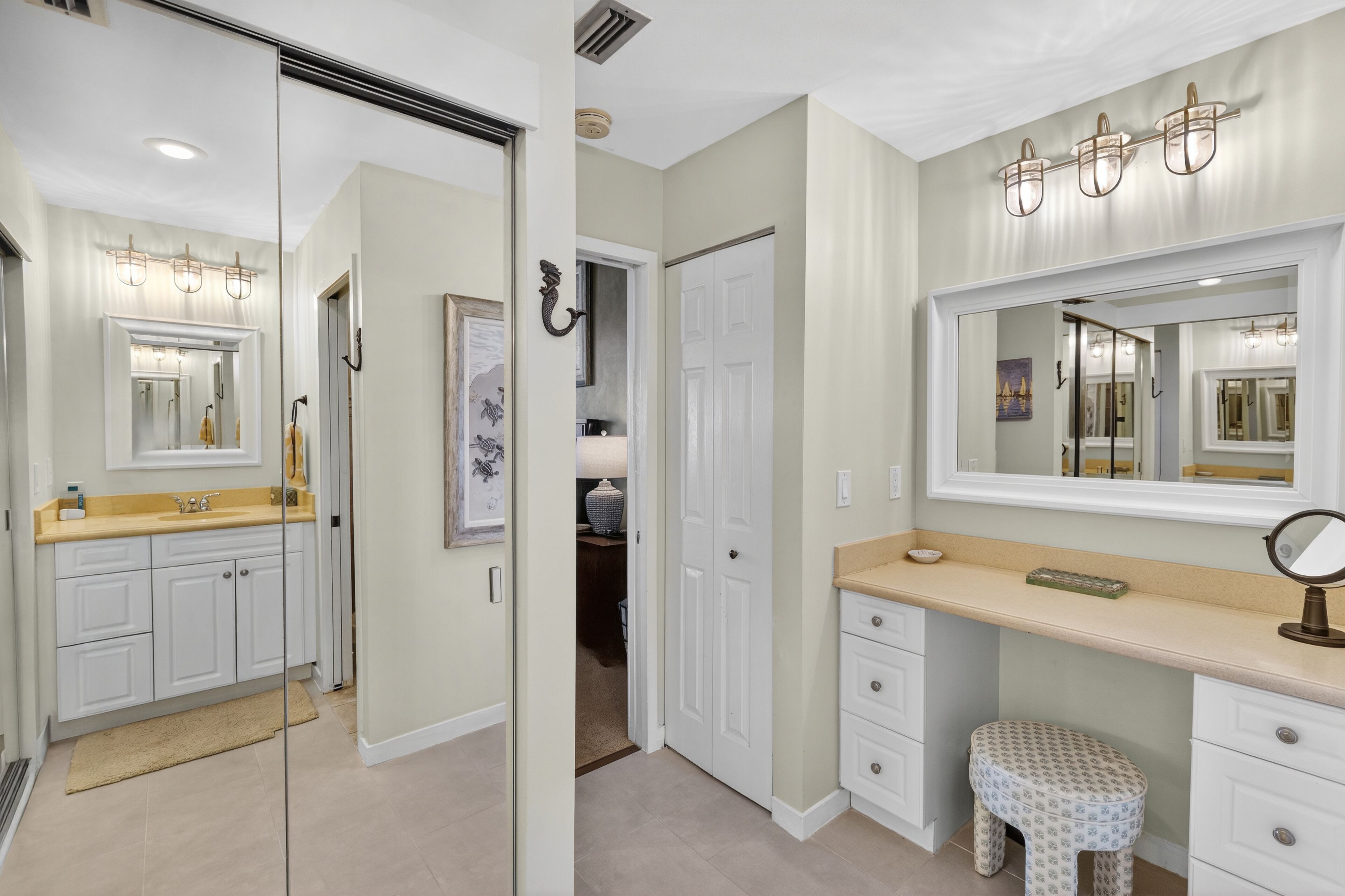 A bathroom with a vanity, a mirror, a sink, and a toilet.