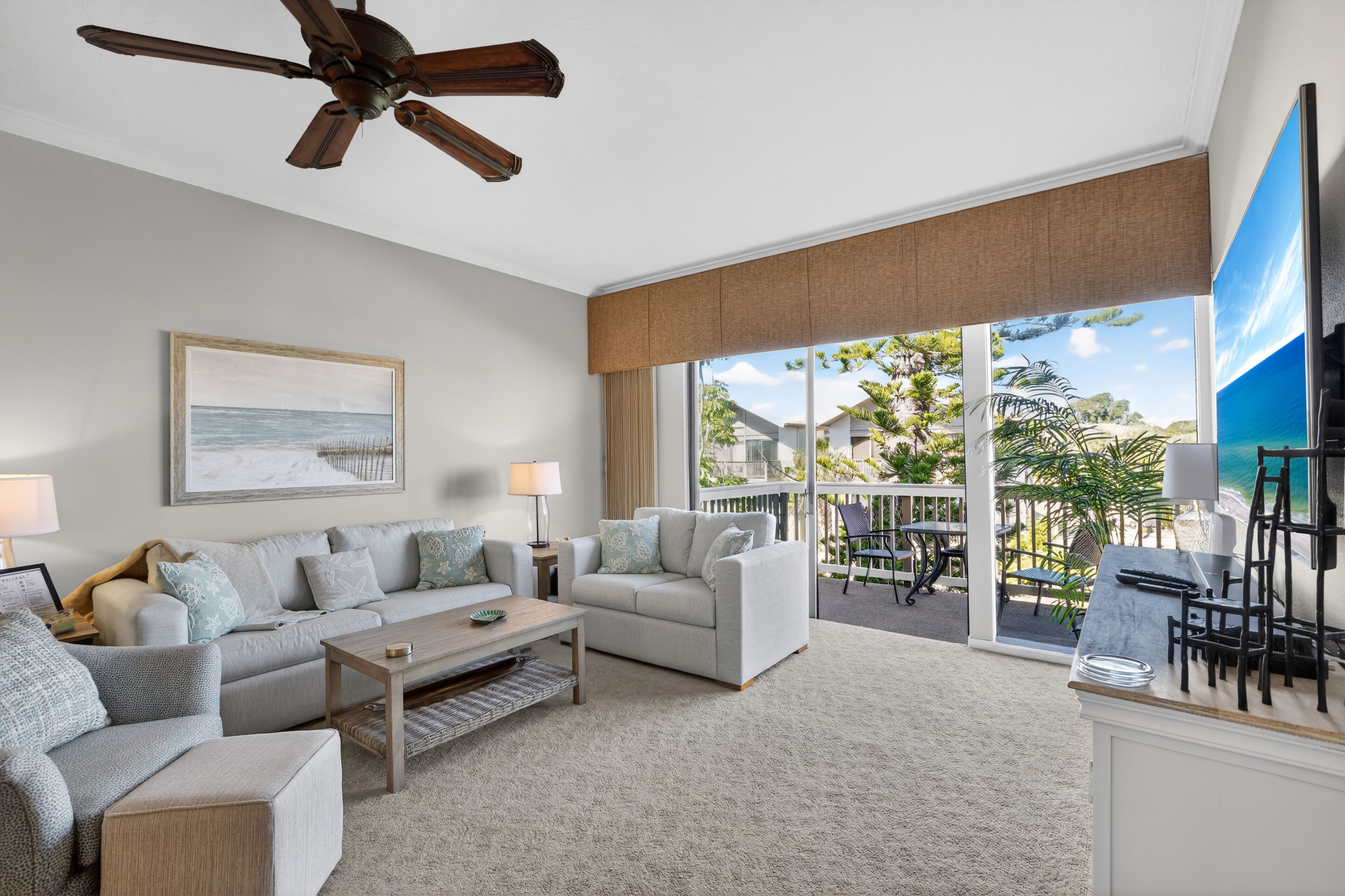 A living room with a sofa, coffee table, and a ceiling fan.