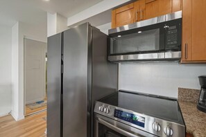 Una cocina moderna con electrodomésticos de acero inoxidable, incluyendo un refrigerador, microondas y estufa.