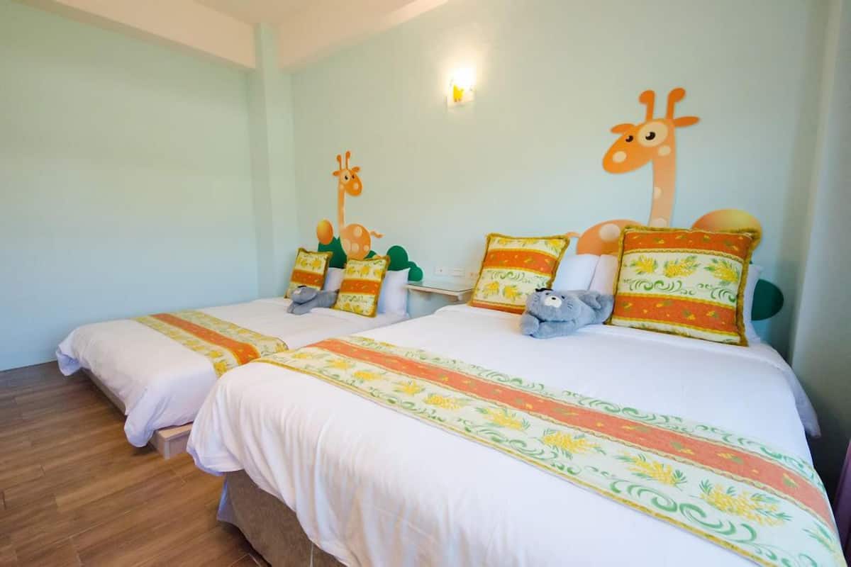 A hotel room with two beds, each with matching pillows and a giraffe wall decoration.