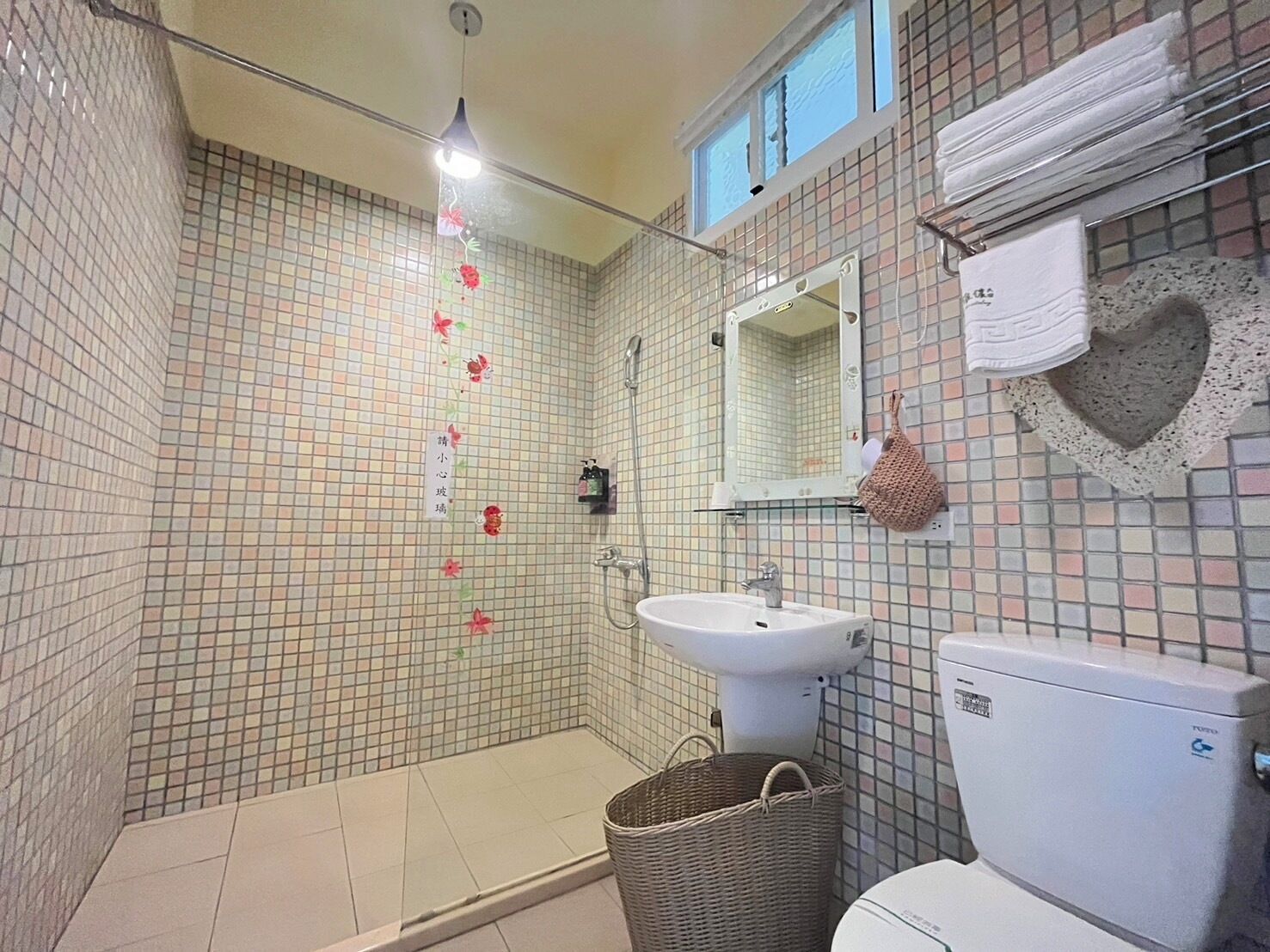 A bathroom with a shower, sink, and toilet.
