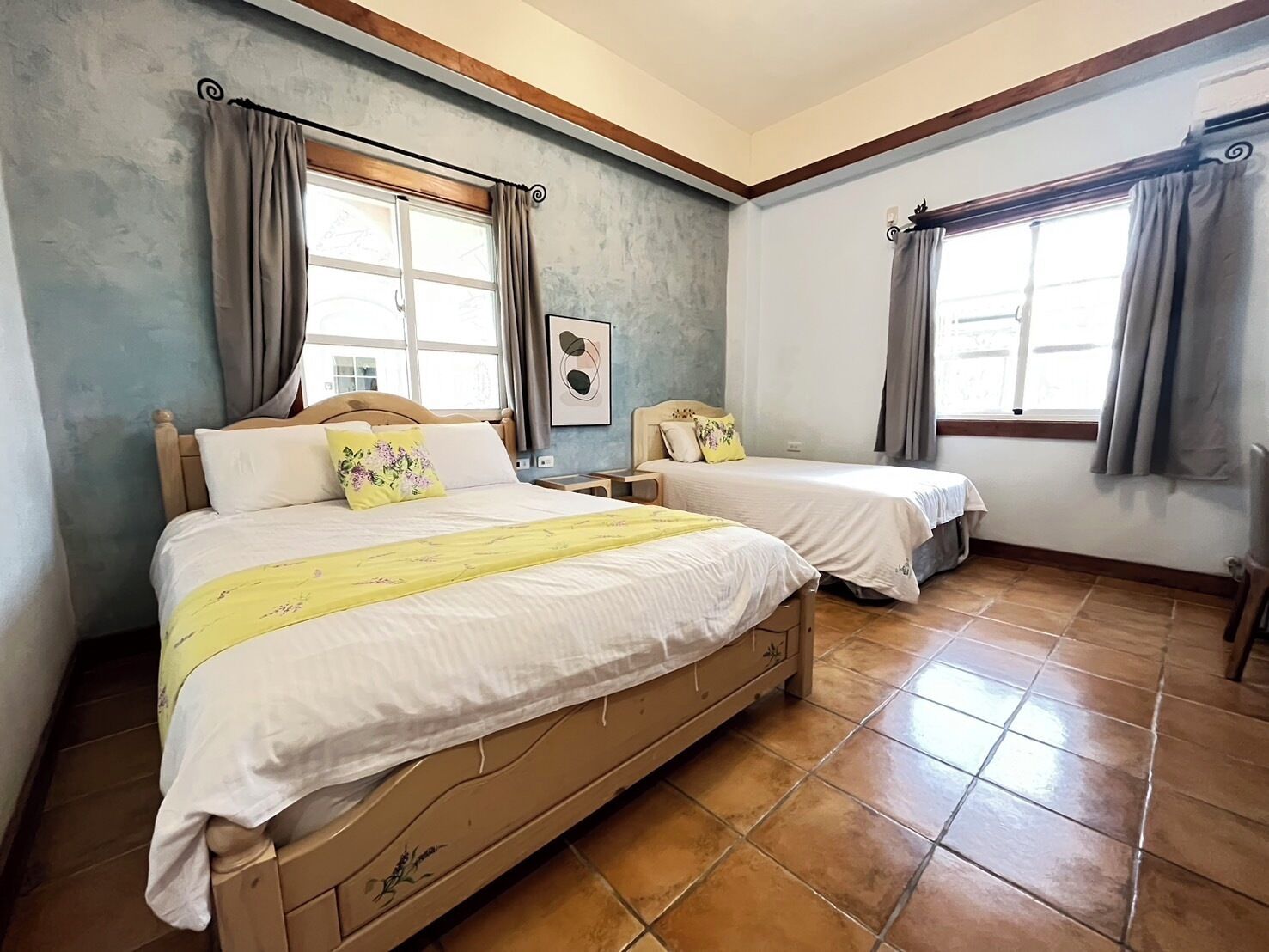 Un dormitorio con dos camas, una ventana y un cuadro en la pared.