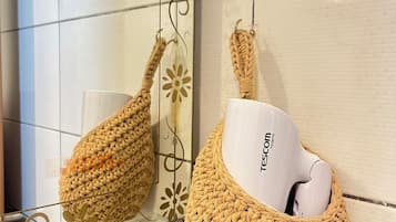 Une salle de bain avec un mur carrelé et une étagère en verre.