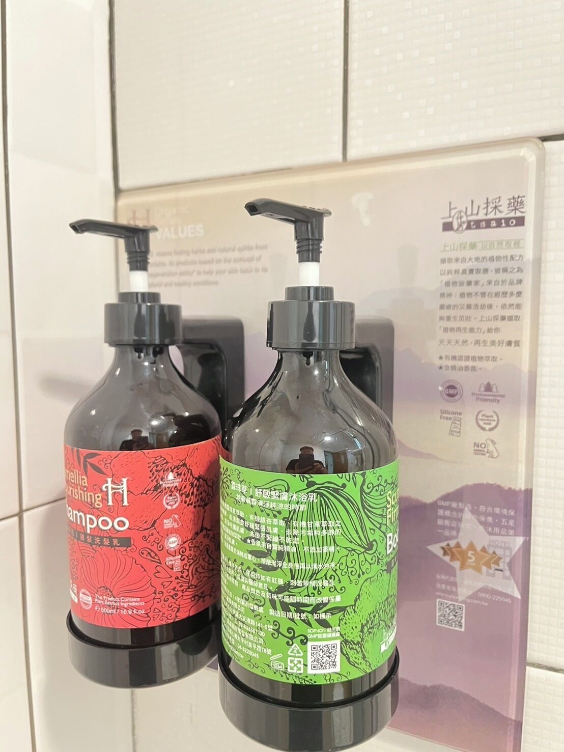 Two bottles of shampoo with pump dispensers on a tiled surface.