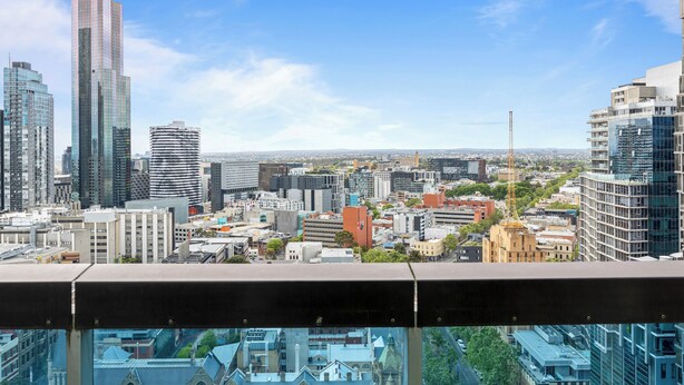 A cityscape with modern high-rise buildings and a historic building in the foreground.