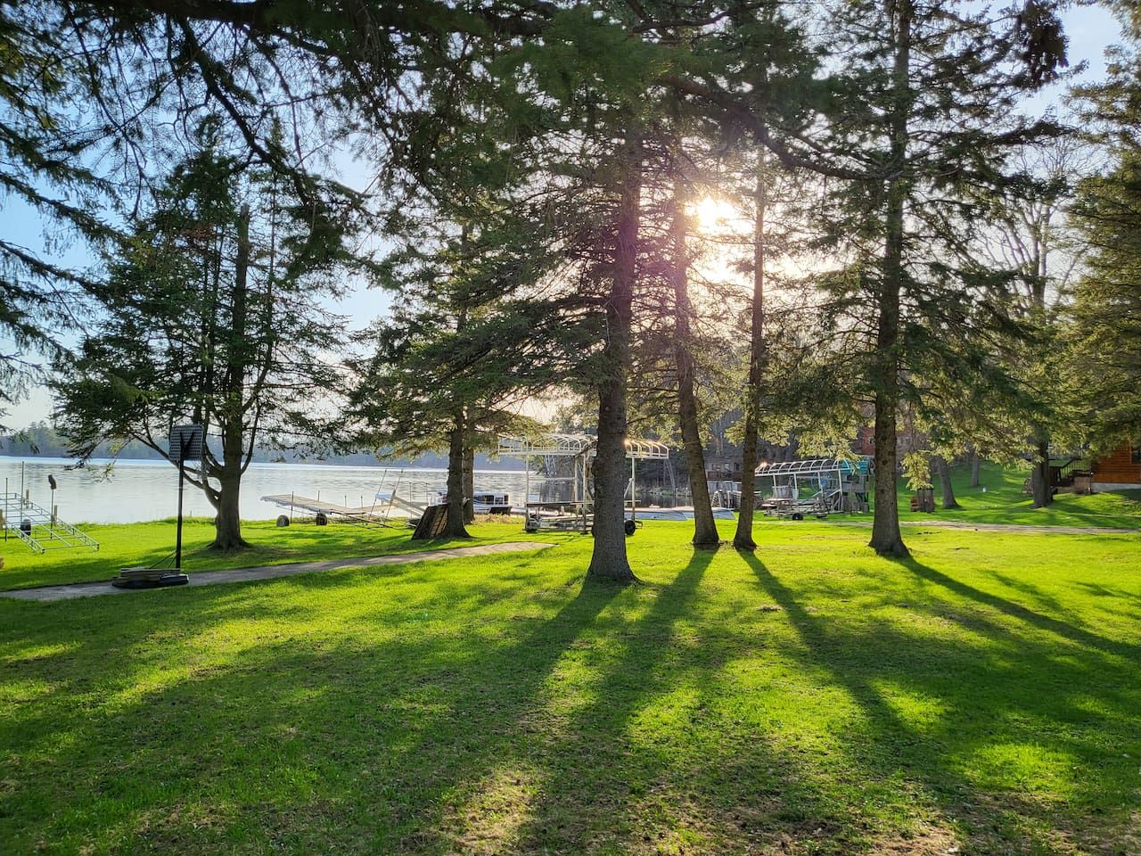 A park with a lake, trees, and a playground.